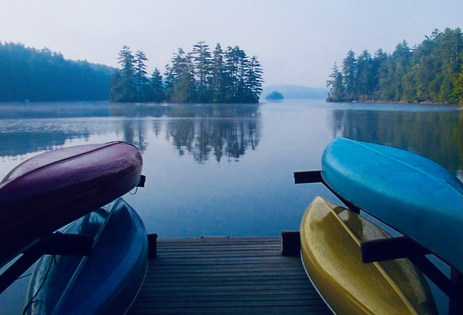 Serene lake view at Camp Ladd with colorful kayaks on the dock